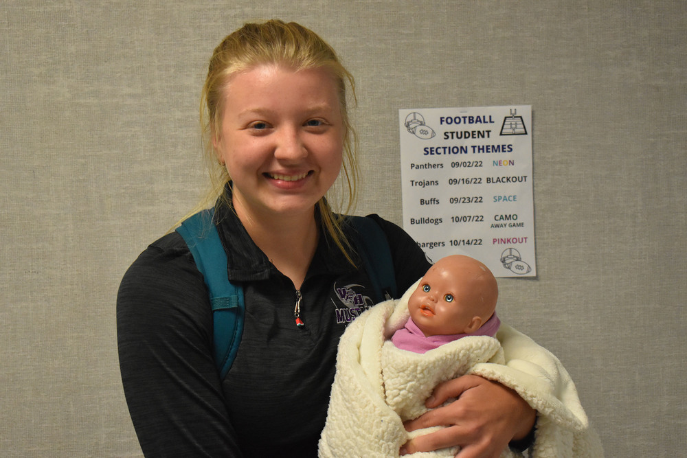 Audra Steinfort holding her baby doll from her childhood 