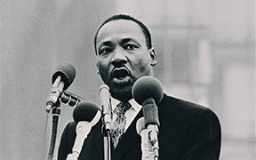 Martin Luther King Jr. is depicted here inspiring others through one of his speeches.