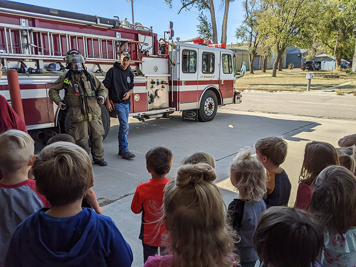Kids standing during presentation at the fire house.